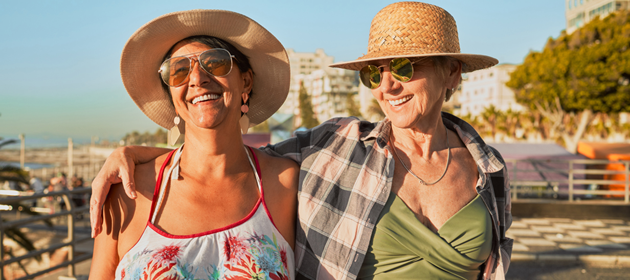 femmes âgées marchant sur la plage et souriant